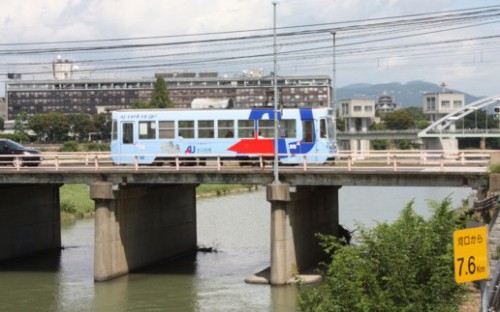 岡山城をﾊﾞｯｸに小橋を渡る7401号